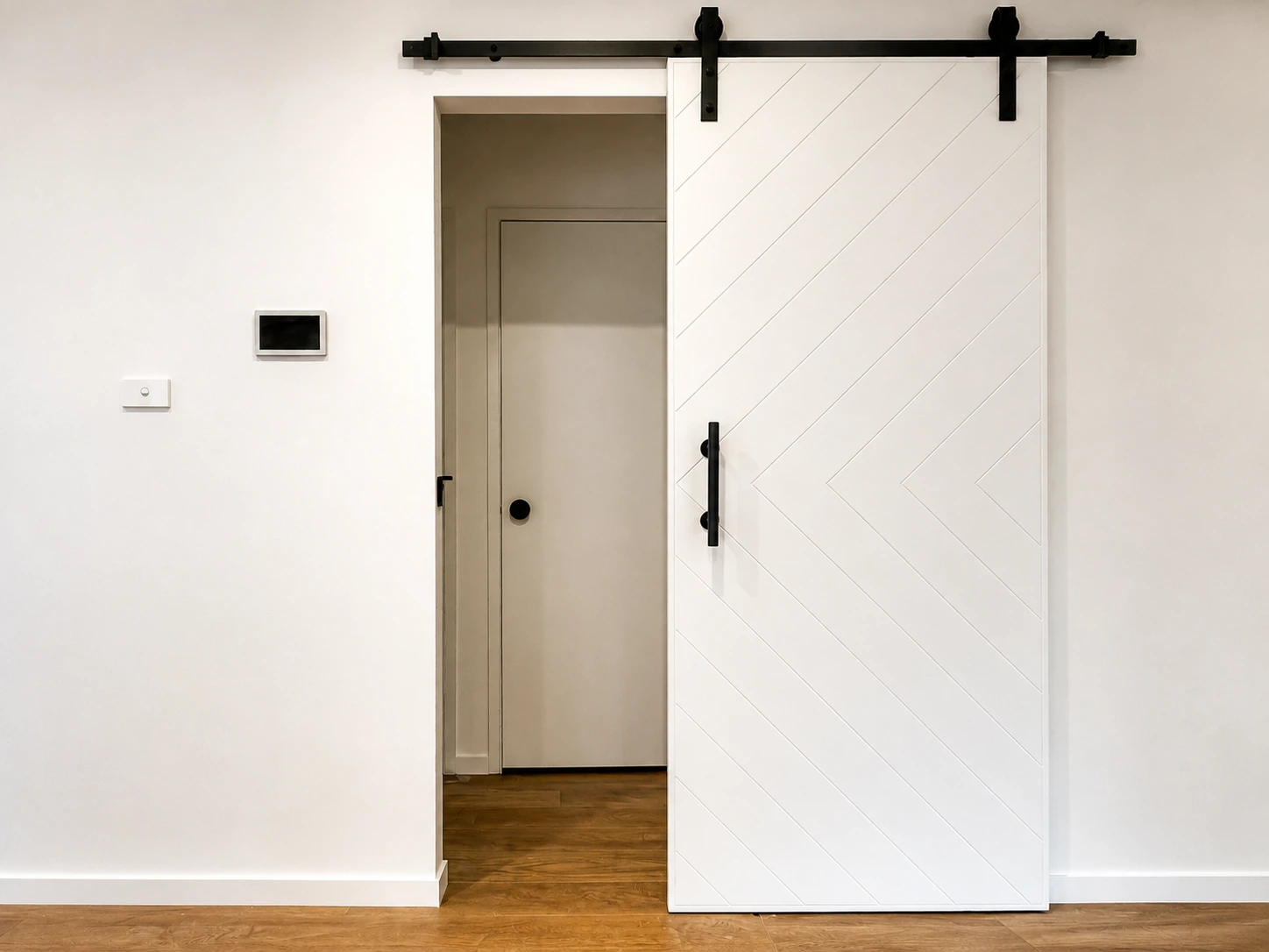 Black-hardware barn door on an exposed track in the renovated Castle Hill home, opening off the timber-floored hallway