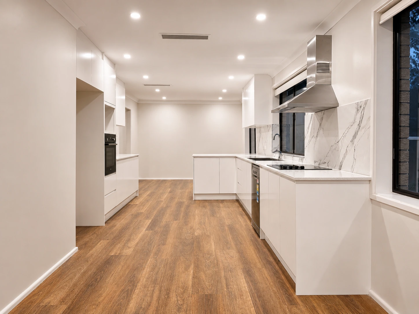 Castle Hill kitchen — white handleless cabinetry, marble-look splashback and warm timber-look flooring
