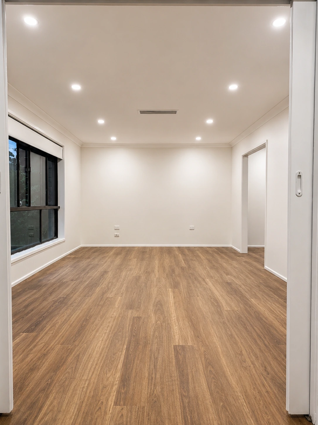 Castle Hill living room — black-framed windows and warm timber-look flooring after renovation