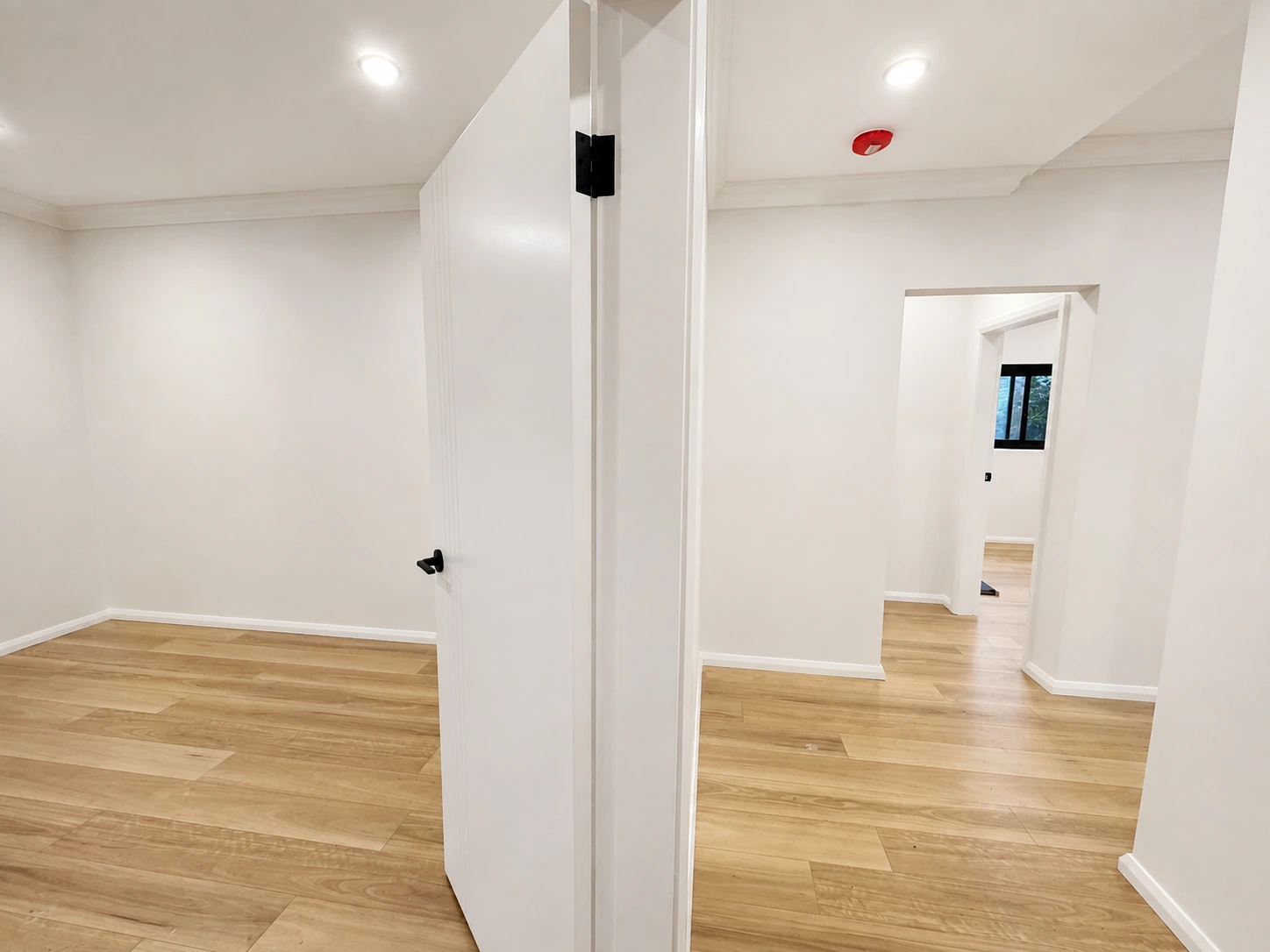 Newly finished rooms off the Strathfield hallway — repainted walls, new doors with black hardware and timber floors carried through