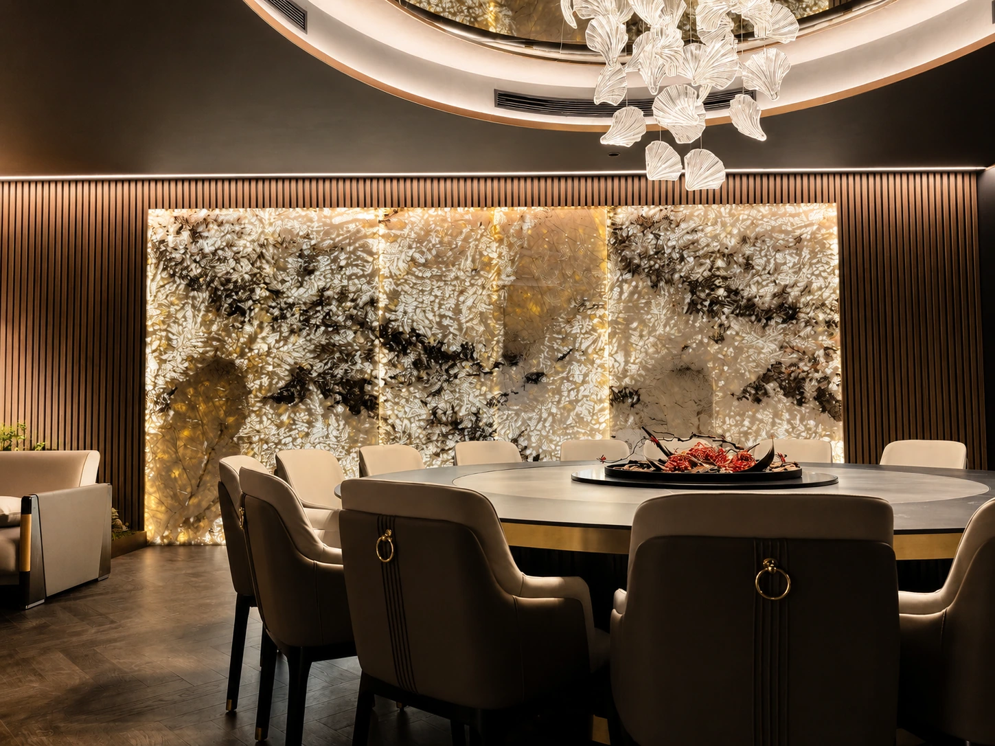 Private dining room in a Silverwater entertainer's home — backlit marble feature wall, round banquet table and a glass-leaf chandelier