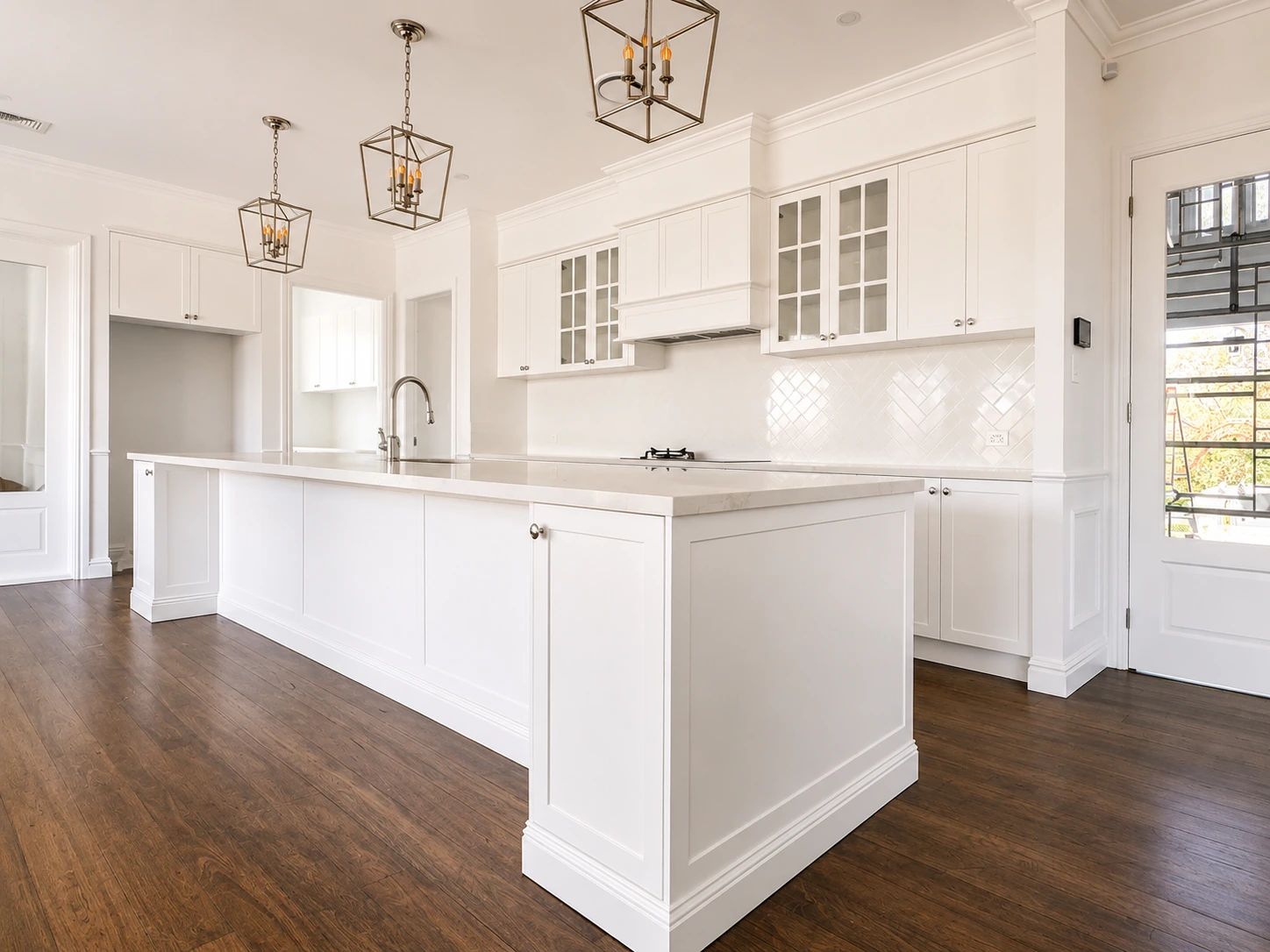 Willoughby kitchen island — shaker joinery, glass display cabinets, herringbone splashback and a gas cooktop